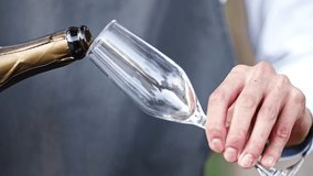 close-up. the waiter's hands with a glass and a bottle of champagne. Sparkling wine is poured into a glass. A traditional drink for special events. - Powered by Shutterstock - Get 15% off with code: PIKWIZARD15