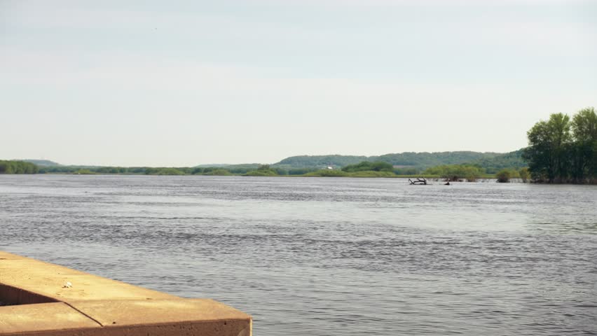 The Iowa shore of the Mississippi river shines in the sun.