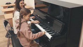 Woman and child at piano sharing creative moment, music filling room, piano keys expressing emotions, music passion inspiring connection, bonding through notes and melody - Powered by Shutterstock - Get 15% off with code: PIKWIZARD15