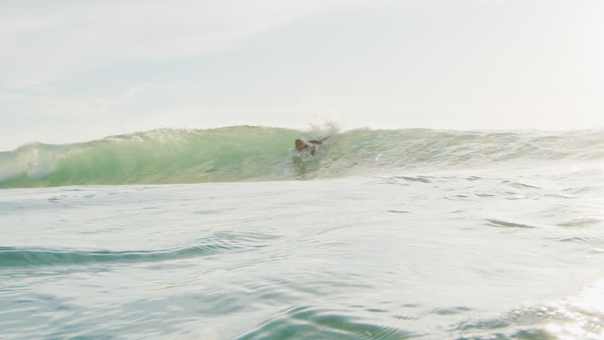 Surfer rides the wave in Brazil and passes by the camera