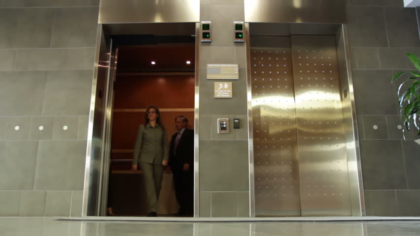 Business people get out of an elevator and leave frame. Wide view, recorded from