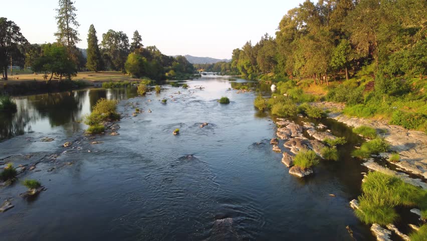 Reveal White Water Rapids on Lush Oregon River at Sunset. North Umpqua River, Roseburg. Summer Low Water Line Showing Green Islands and Vibrant Forests. Slow Calm Reflective Water