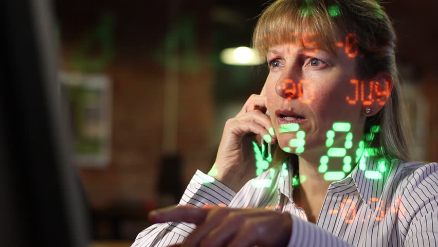 Woman on the phone with stock ticker symbols projected across her as she makes
