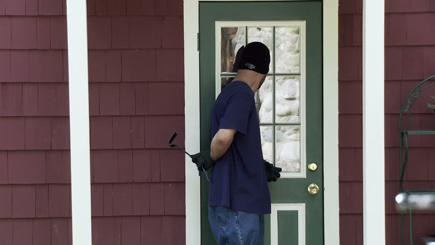 Burglar makes his way up to a house door, looks around, finds the door is