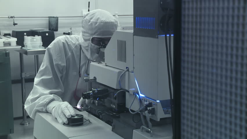 Technician checking a photographic process while working on silicon chip