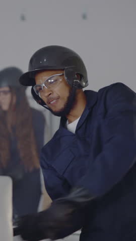 Rage room, angry and man with bat for computer for breaking, vandalism and destruction. Destroy, wreckage and frustrated people with safety glasses for protection for demolition, smash and damage