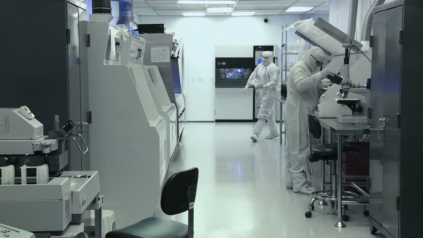 Scientists and technicians working on silicon chip manufacture in a clean room,