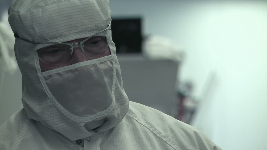 Big close up of a technician working on silicon chip manufacture in a clean