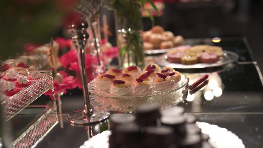A dessert table with a variety of sweets, elegant decor, and a warm party ambiance