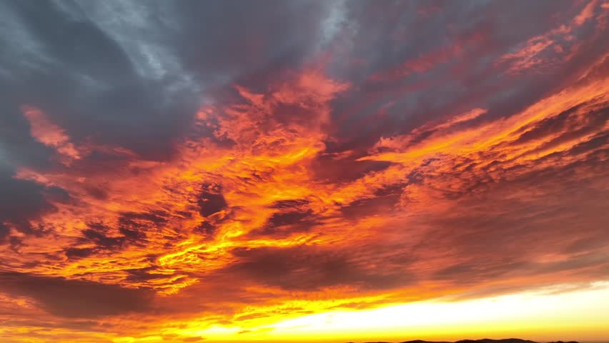 Dramatic colored sunset at sky in american. Flying cloudscape in pink and orange colors. Panorama wide shot in USA: