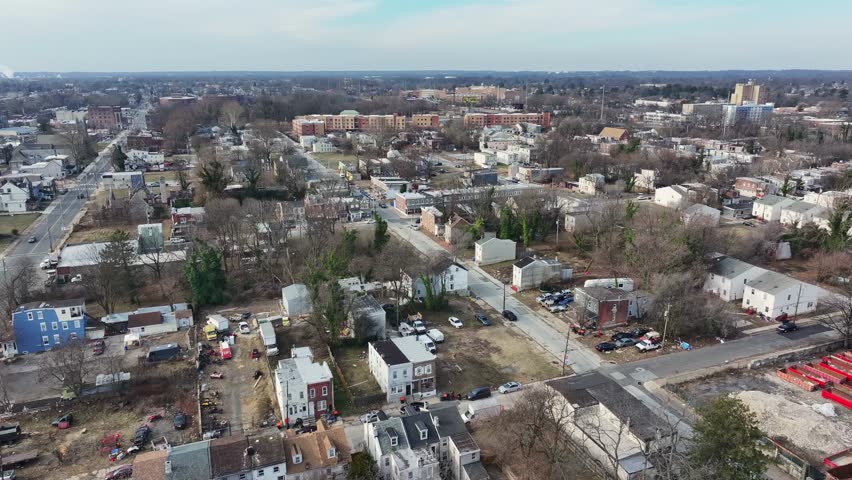 Aerial establishing shot of housing area of american low class neighborhood. Leafless trees in winter season. Old houses in dangerous district. Wide shot.