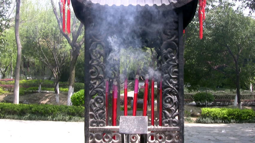 Sunny weather in a Chinese park. Incense smoke in the old national stand