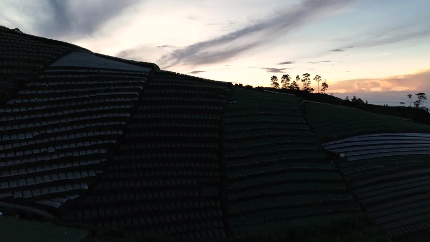 Aerial view of an early morning sunrise on a mountainside with an orange sky.