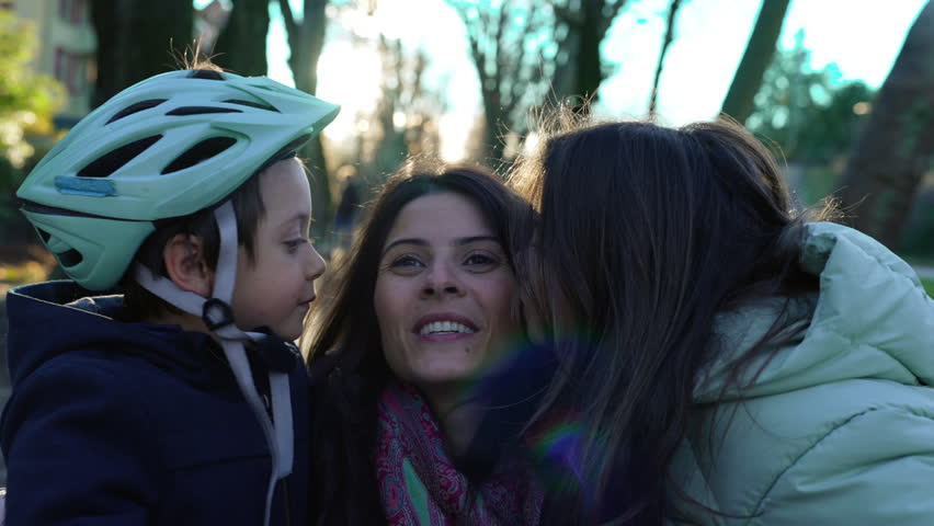Adorable Family Moment - Little Brother and Sister Simultaneously Kiss Mother on the Cheek Outdoors