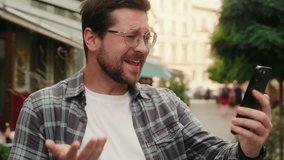 Happy man Caucasian guy funny male tourist traveler blogger vlogger influencer video call mobile phone in city record travel blog video selfie online stream vlog social media smartphone chat laughing - Powered by Shutterstock - Get 15% off with code: PIKWIZARD15