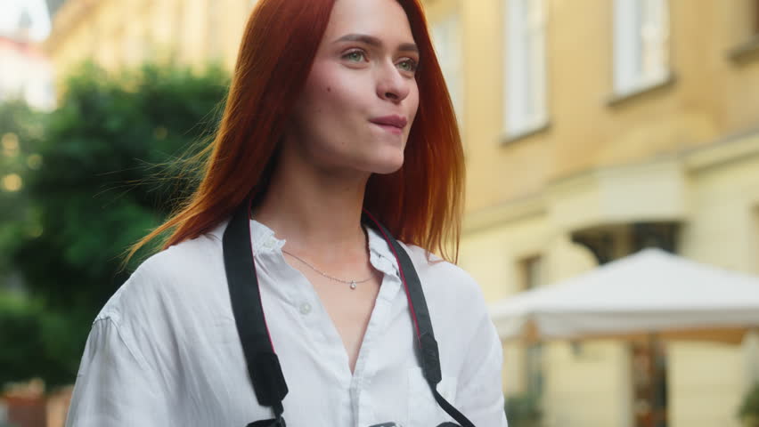 Caucasian girl happy female woman tourist traveler street photographer take picture photo in city outside travel blogging tourism influencer blogger traveling photograph views camera shooting outdoors