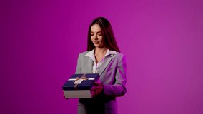 Excited woman unboxes a surprise gift against vibrant purple background during a lively presentation - Powered by Shutterstock - Get 15% off with code: PIKWIZARD15