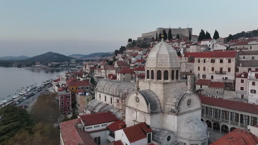 Drone footage captures the Cathedral of St. James, a UNESCO World Heritage Site, showcasing its grandeur and intricate architecture against the backdrop of Sibenik