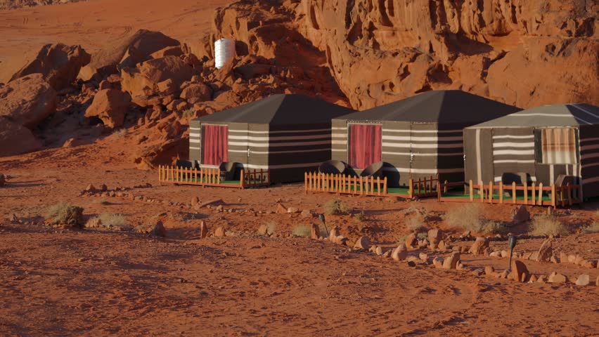 A row of Bedouin tents in a desert camp in Wadi Rum, Jordan.