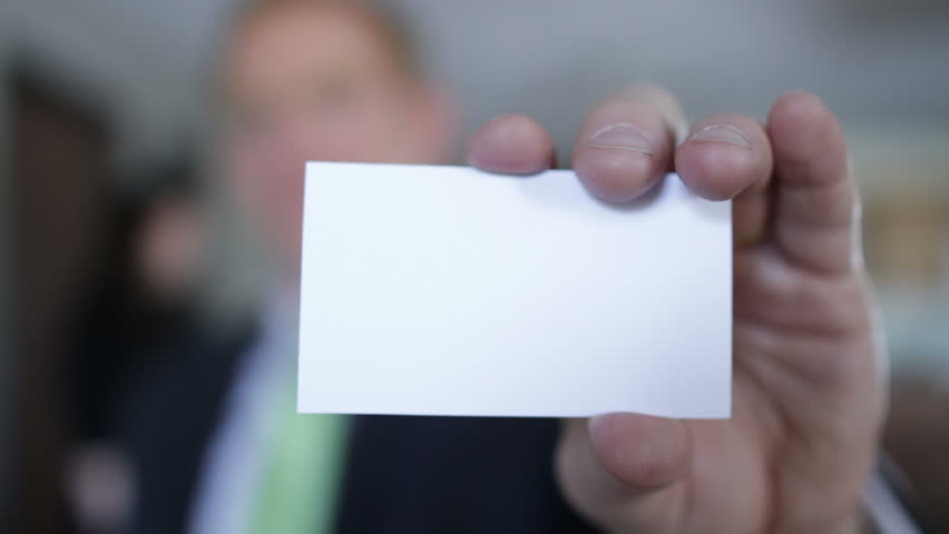 Business man holds up a blank business card to the camera. If last frame is