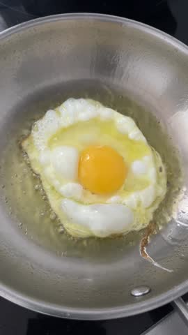 Frying an Egg in Olive Oil on a Stainless Steel Pan