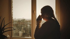 Happy Elderly senior woman looking out window drinking herbal healing tea enjoying morning sun light. Unhappy lonely Old age lady person silhouette back rear view holding cup. room home. rest pension - Powered by Shutterstock - Get 15% off with code: PIKWIZARD15