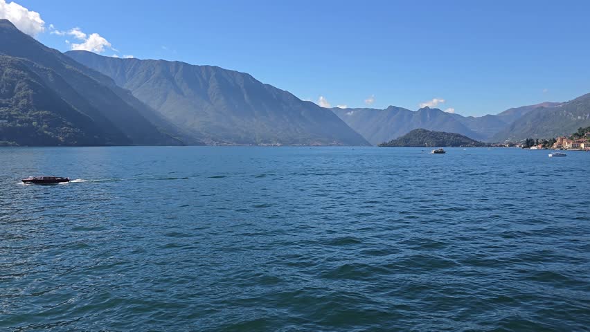 The tourist boats sailing on Lake Como off the shore of Bellagio town in Lombardy region, Northern Italy, on a clear sunny day