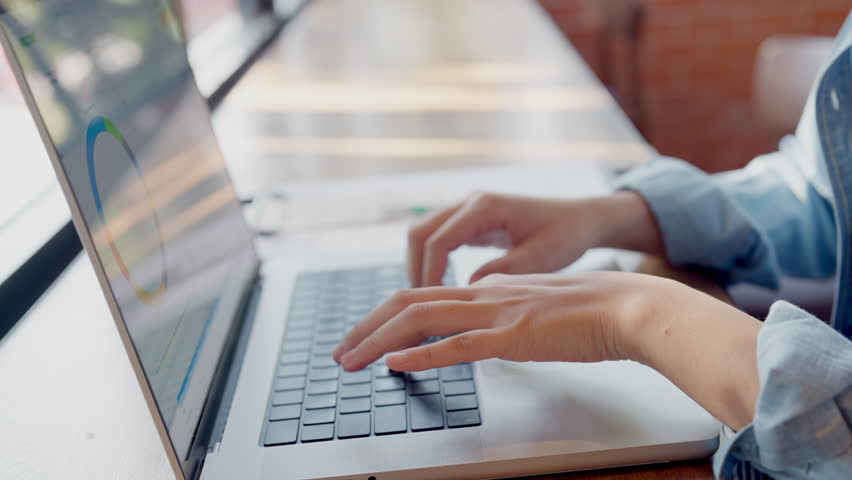 A person is typing on a laptop computer. The laptop is open and the person's hand is on the keyboard. The person is likely working on a project or writing an email. Scene is focused and productive