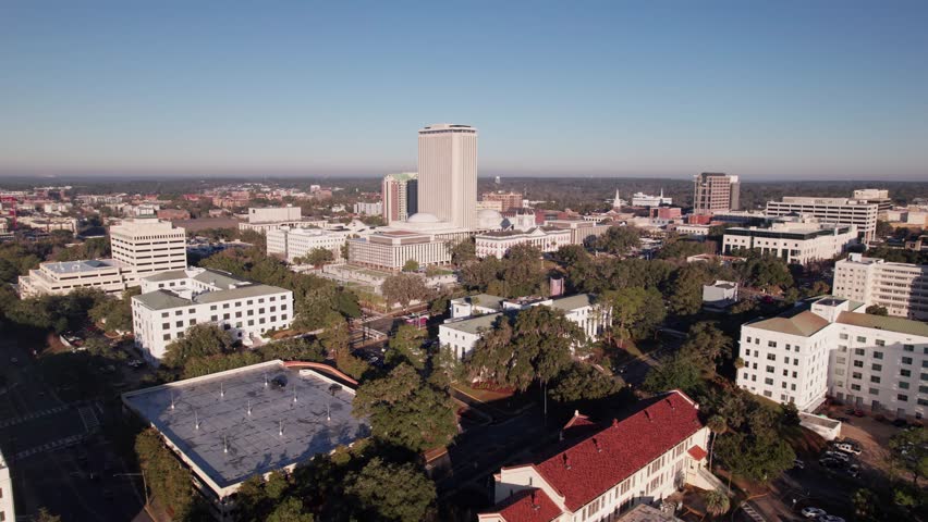 Drone landscape aerial of capital city Tallahassee, Florida with capitol building, federal legislature chambers, and governor office along with buildings, university, apartments, offices, and roads