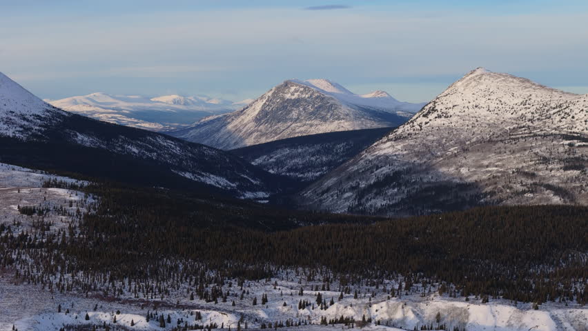 Cinematic aerial view near Fish Lake and snow-covered wilderness. Yukon’s frosty landscapes and mountains shine in Canada’s winter light.