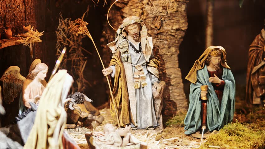 Nativity scene with detailed figurines, moss, straw under warm, festive lighting