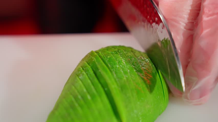 Avocado cut into thin slices. Avocado cutting concept.