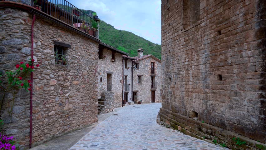 Landscape of a medieval village in the Pyrenees with mountains in the background and camera movement. From Beget, Girona, Catalonia, Spain, Europe.