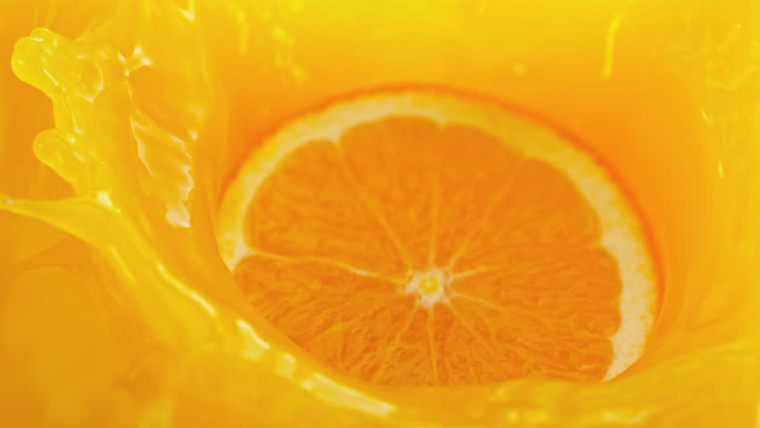 Super Slow Motion Shot of Orange Slice Splashing into Fresh Juice at 1000fps.