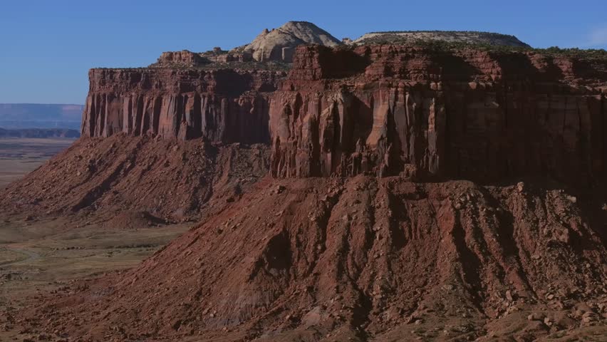 A red rock canyon landscape under clear blue skies, featuring Indian Creek