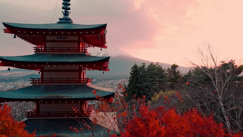 Enchanting view of Chureito Pagoda framed by vivid red autumn foliage during peak momiji season, with Mount Fuji majestically rising in the background.