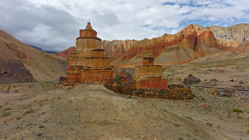 Stunning footage of a Tibetan Chorten standing tall against the rugged, dramatic landscape of Upper Mustang, Nepal