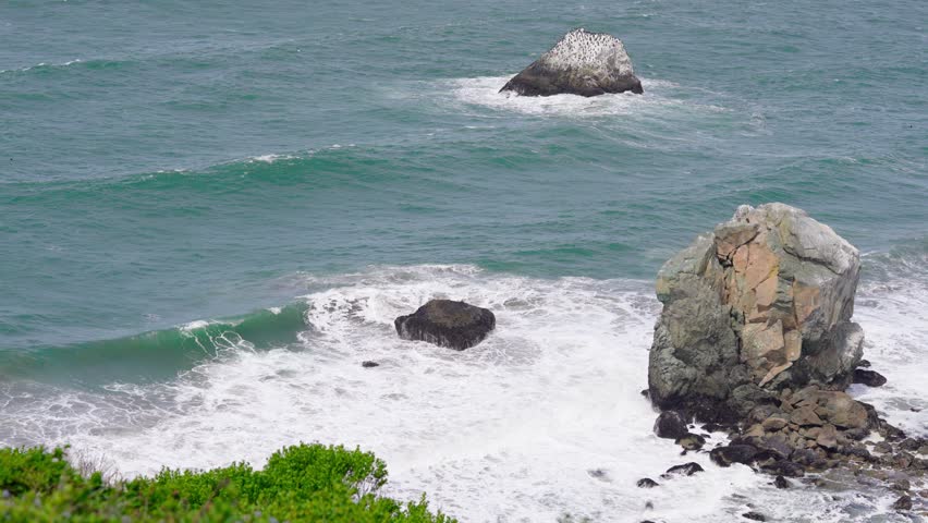 Rough Waves crashing against Large Rocks at Lands End Lookout in San Francisco. 4k slow-motion video.