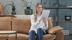 Young Woman Using Tablet while Sitting on Sofa at Home - Powered by Shutterstock - Get 15% off with code: PIKWIZARD15