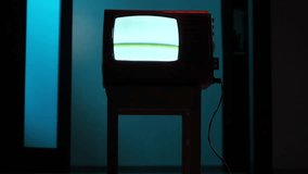 Old analog television set displaying static screen in dark room - Powered by Shutterstock - Get 15% off with code: PIKWIZARD15