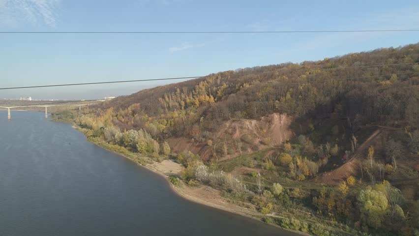 River with a bridge over it and a forest in the background. The sky is clear and the sun is shining. The city of Nizhny Novgorod, near the Oka River. Russia
