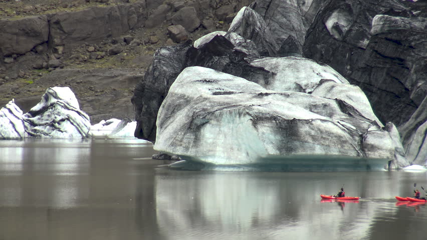 Aerial view of people on kayaks sailing in the glacial lagoon of Solheimajokull Glacier, in southwest part of Iceland.