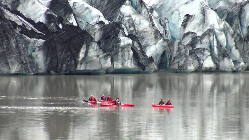 Aerial view of people on kayaks sailing in the glacial lagoon of Solheimajokull Glacier, in southwest part of Iceland.
