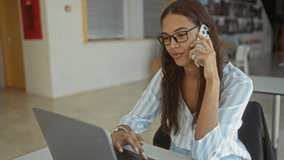 Woman talking on the phone while working on a laptop in a modern office setting - Powered by Shutterstock - Get 15% off with code: PIKWIZARD15