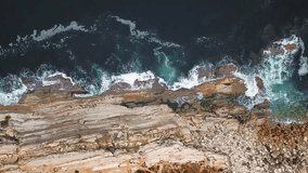 Breathtaking drone perspective of Baleal, Portugal, revealing rugged cliffs meeting the powerful Atlantic Ocean. Turquoise waves crash against the rocky shoreline, creating a mesmerizing coastal scene - Powered by Shutterstock - Get 15% off with code: PIKWIZARD15