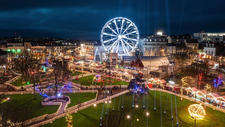 Galway , Ireland - 12 26 2024: Festive Christmas night market scene with light display and ferris wheel at Eyre Square