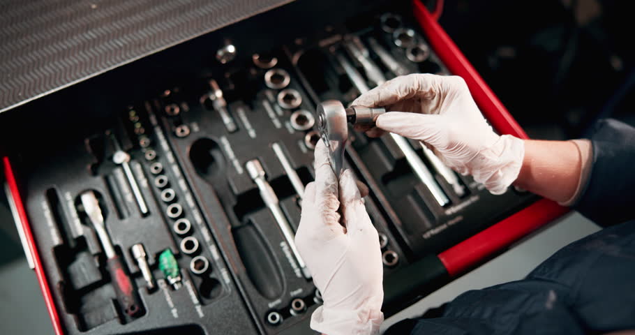 Engineer, toolbox and hands with tools in garage for car maintenance, repair service and vehicle testing. Motor industry, above and person choose a ratchet spanner in workshop for auto inspection