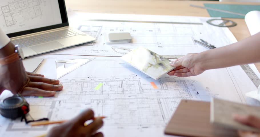 Reviewing blueprints and materials, architects collaborating on construction project. Architecture, collaboration, planning, teamwork, building