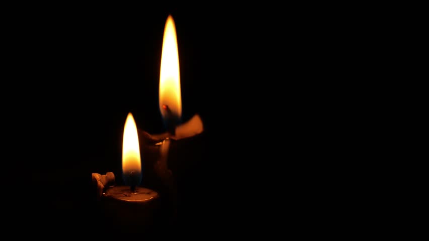 Flames of two burning candles and black wax drips in the dark.Black candles on a black background.Magical and witchcraft atmosphere. Symbol of sorrow.Dark mood. 4k 