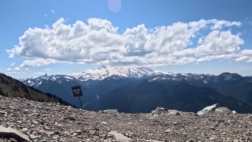 A scenic view of Mount Rainier National Park in Washington state under clouds on a sunny day